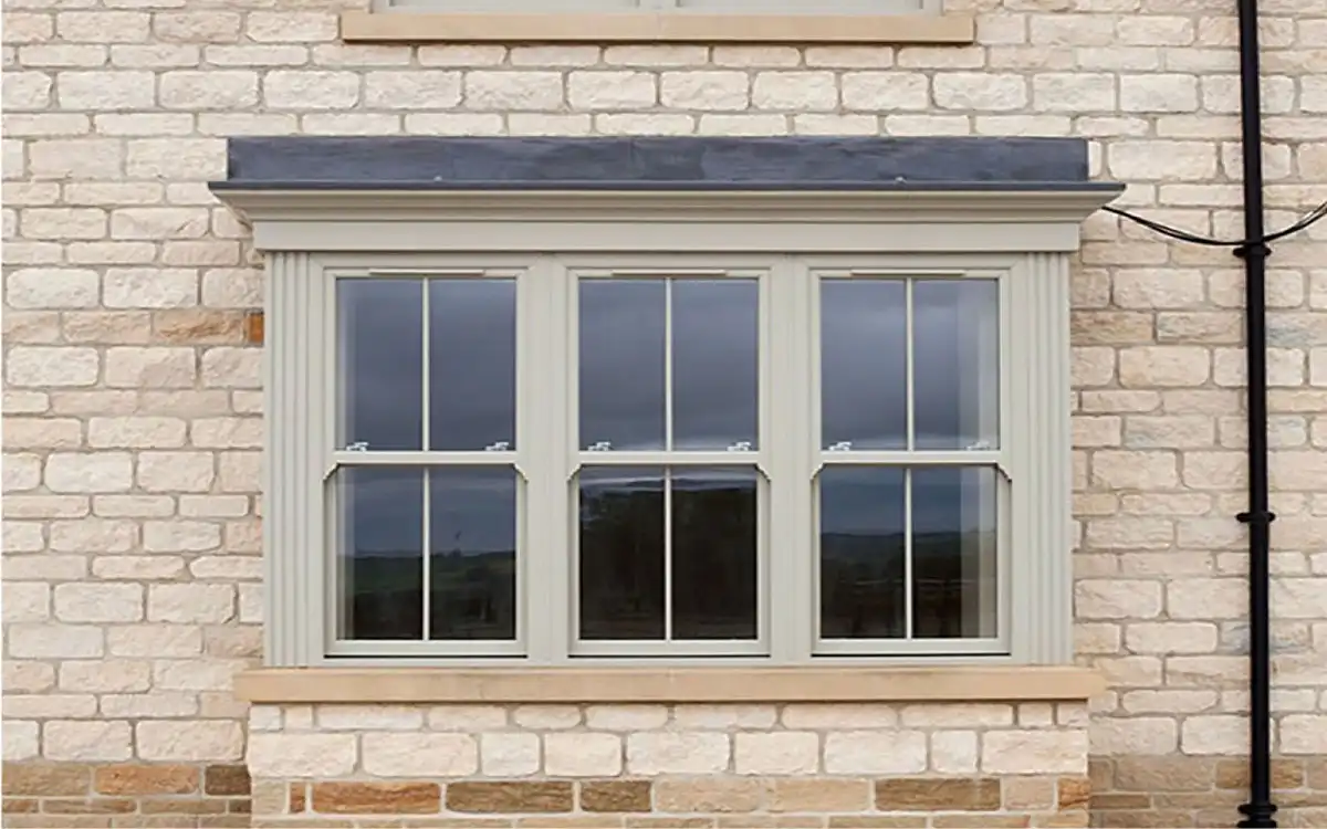Traditional cream sliding sash windows on a light stone exterior.