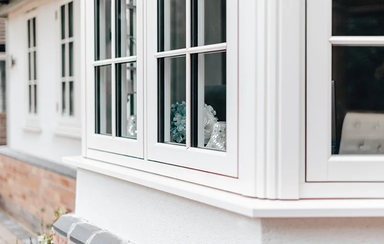 Close-up of a modern white bay window with decorative glass panels.