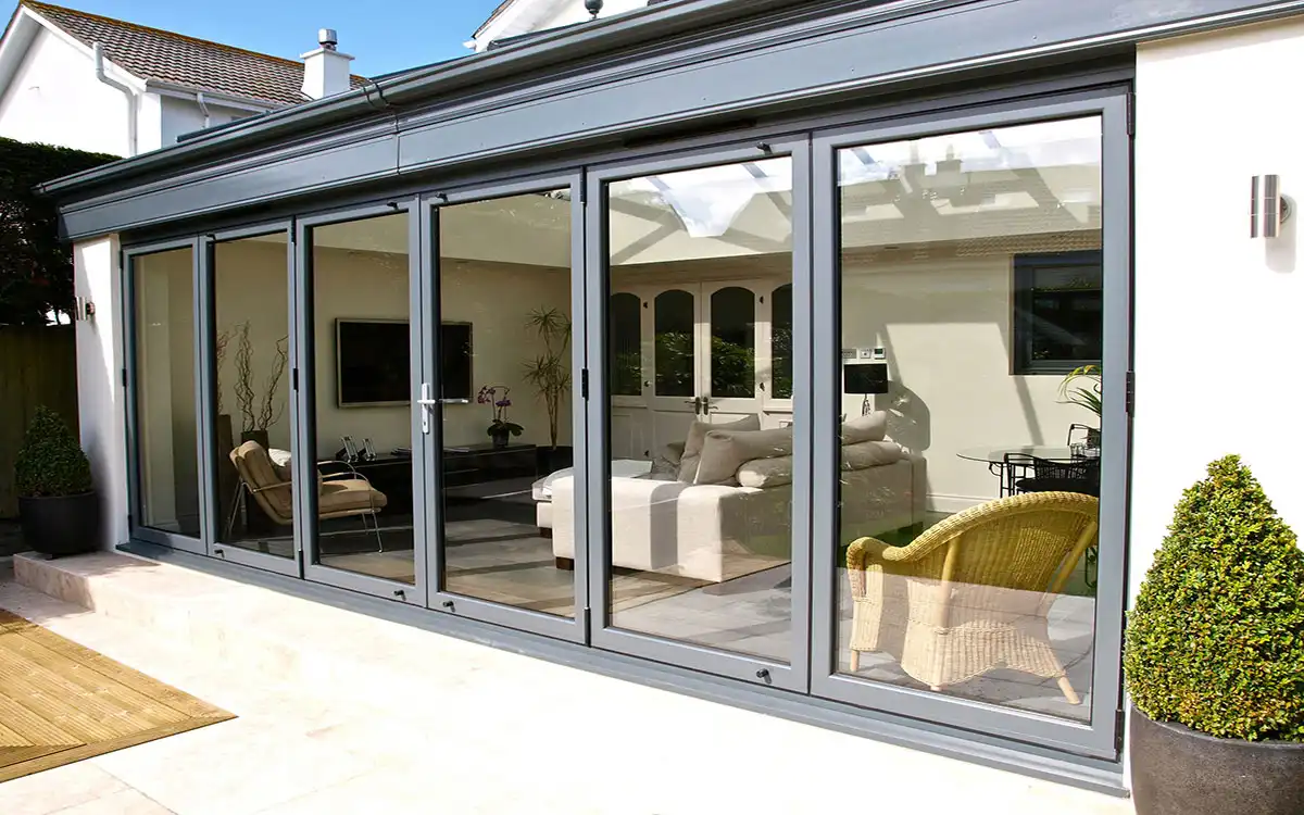Grey aluminium bi-fold doors opening to a modern living space.