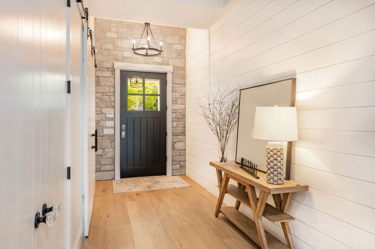 Modern wooden door with upper glass panels in a well-lit, stylish hallway