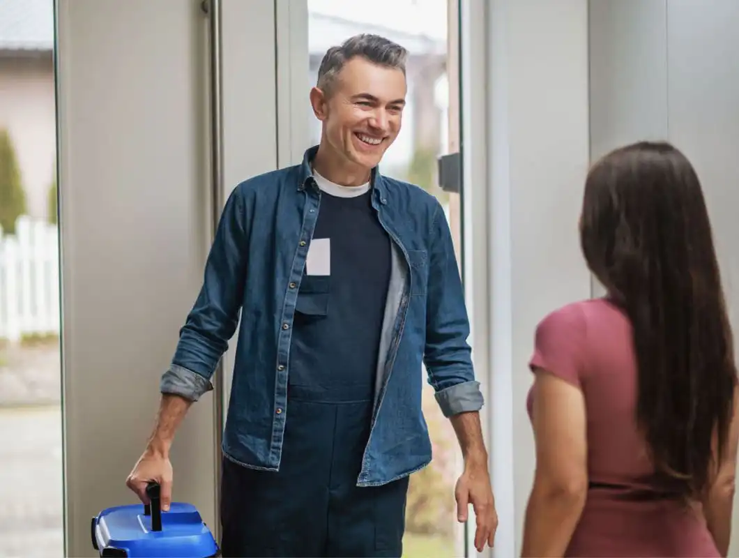 Smiling installer arriving at a customer’s home with a blue toolbox ready for service