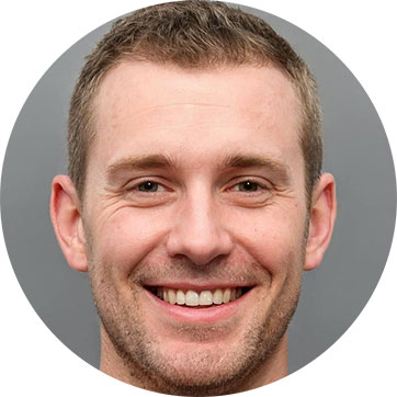 Smiling man with short hair and stubble against a grey background.
