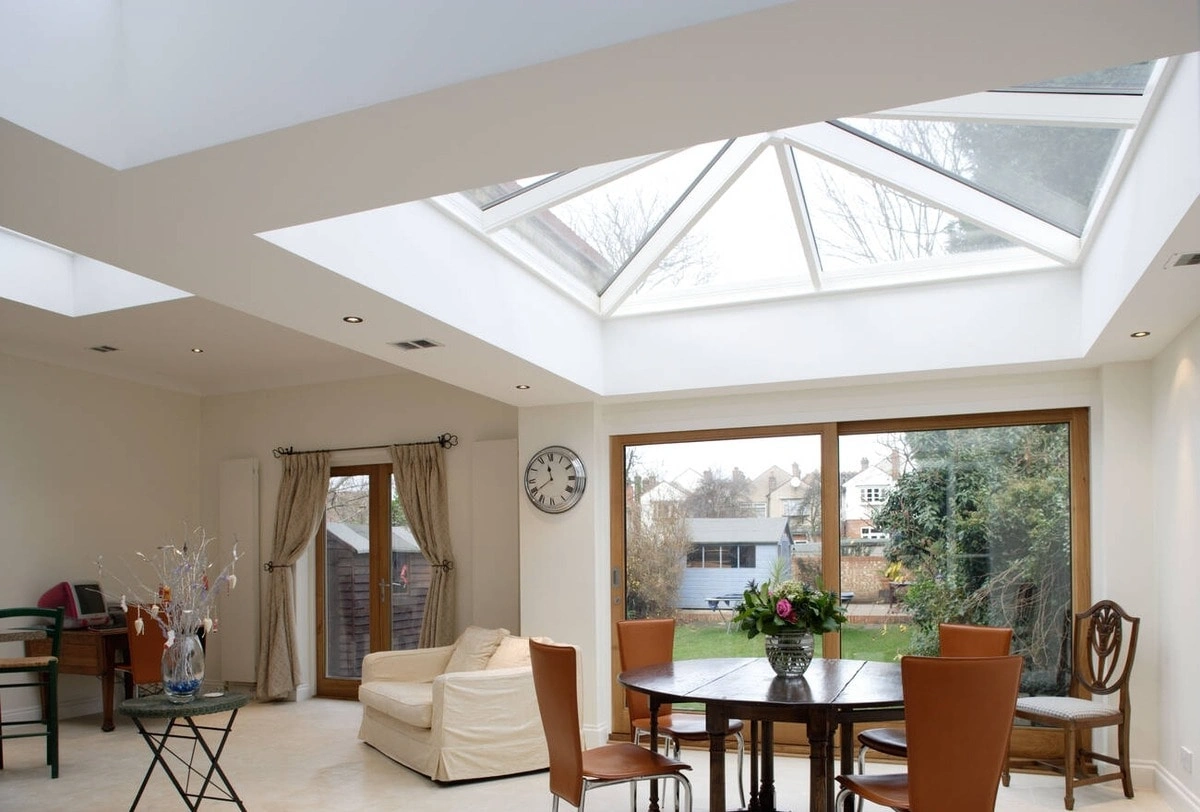 Modern dining area with roof lantern, sliding glass doors, and natural light.