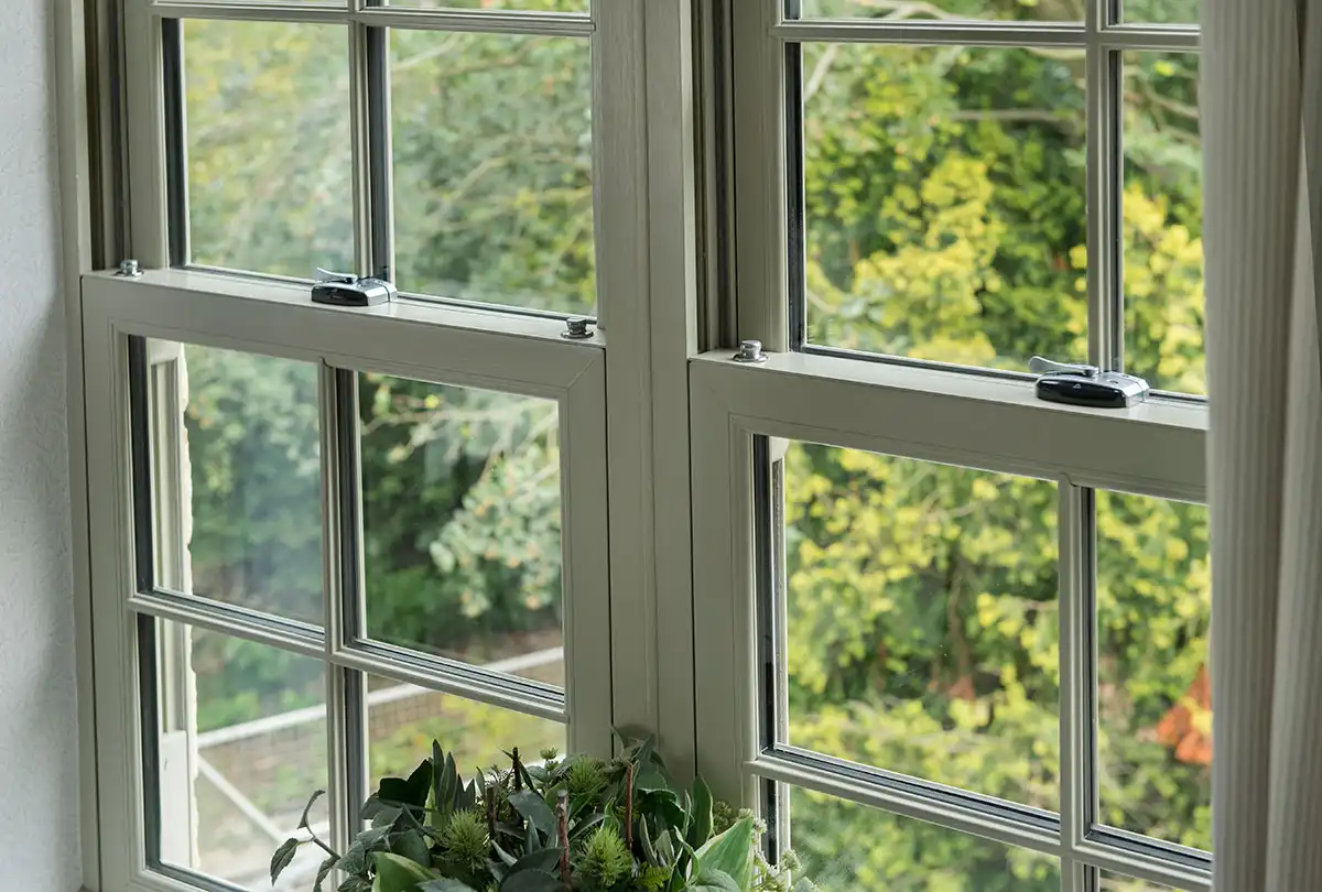 Interior view of a traditional sash window in agate grey with garden scenery.