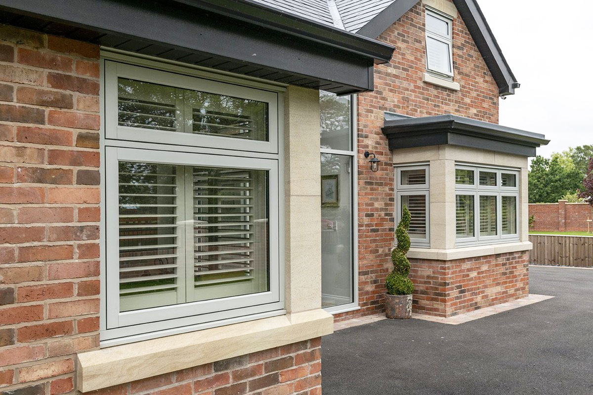 Timber-look flush sash windows in a painswick finish on a modern brick house.