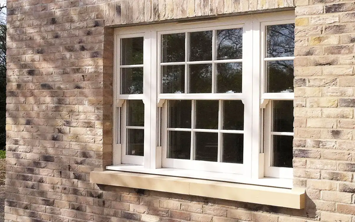Cream vertical sliding sash windows on a light brick exterior.
