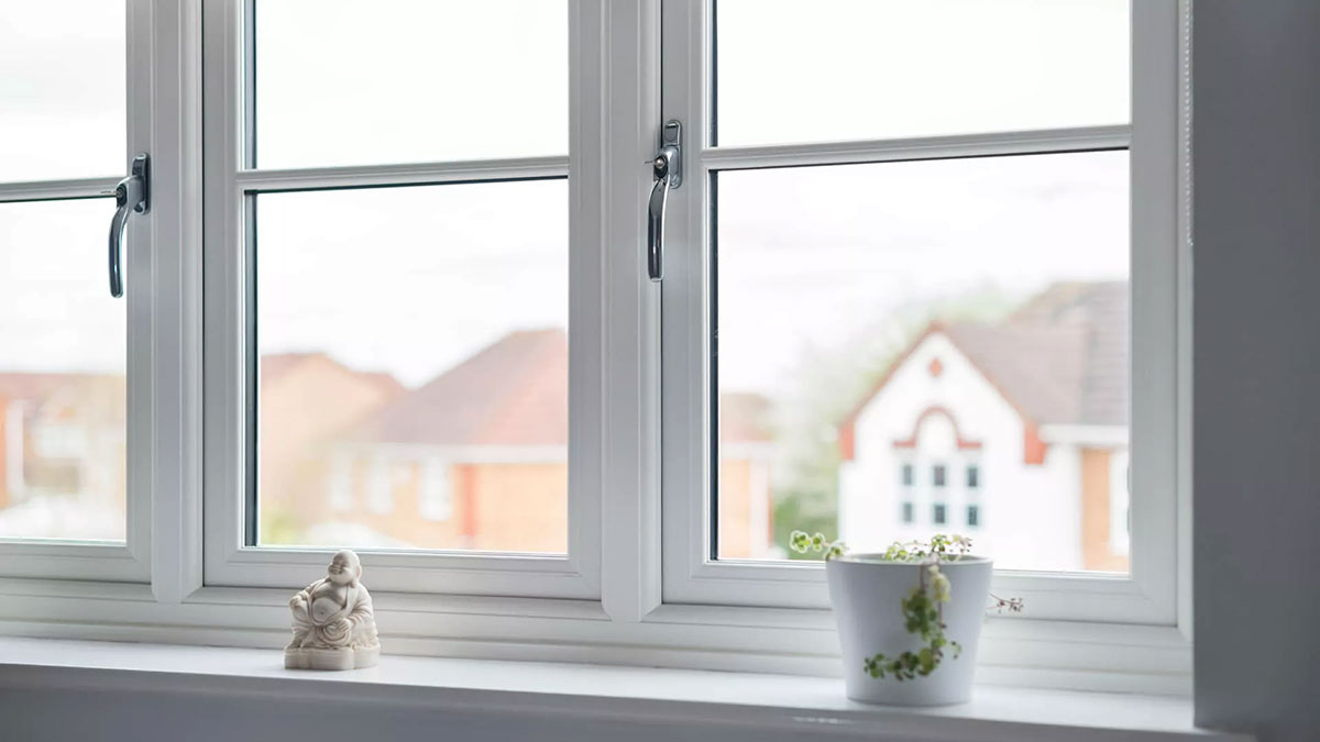 Interior view of modern white flush casement windows with chrome handles and a bright outlook