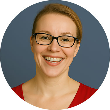 Smiling woman with glasses and tied-back hair wearing a red top against a grey background.