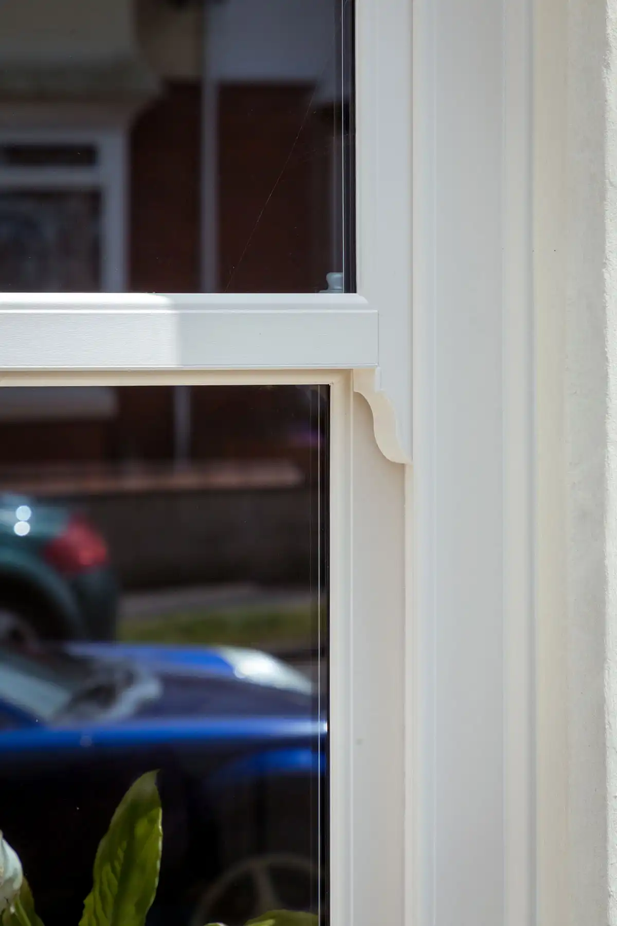 Close-up of a white timber window frame with decorative detailing.