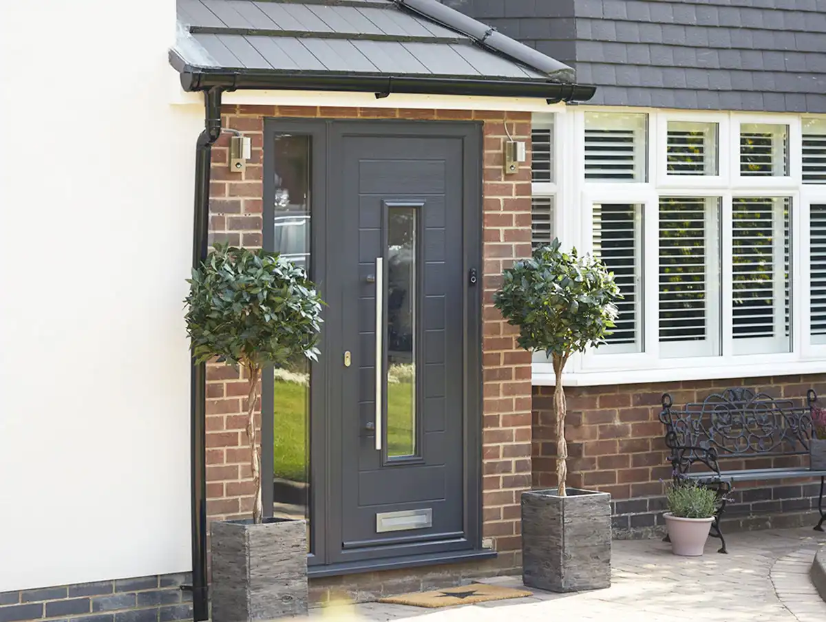 Anthracite grey composite front door with glazed panel and side light, set in a red brick exterior with white uPVC windows